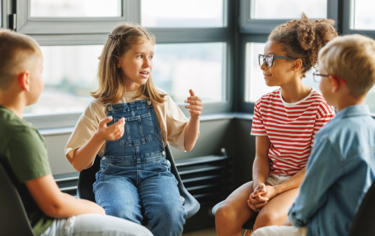 A group of school children discuss a collective project at school.
