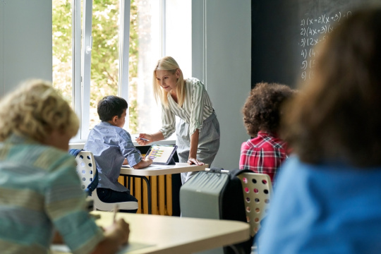 teaching helping student on tablet