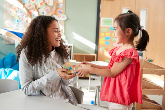 Young student giving teacher a present