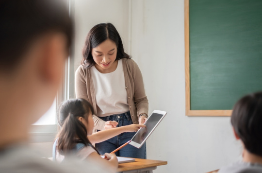 Teacher and young student looking at a tablet