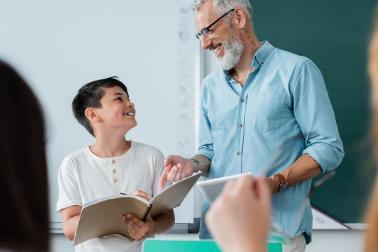 Student and teacher smiling and looking at each other