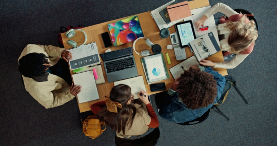 Above, group of school technology professionals meet in library for strategy session.. 