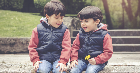 Two young boys sitting in a park