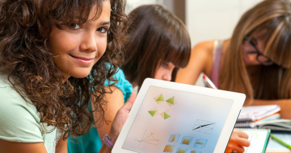 Girl showing tablet with math manipulatives on screen