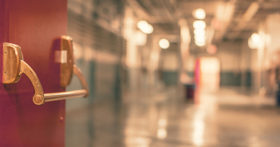 red door to a school opens to hallway