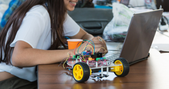 School girl coding to operate a robot in class