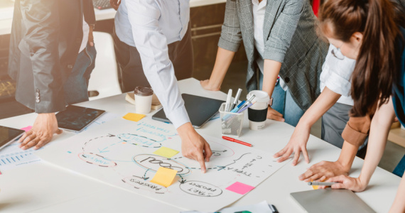 A product development team brainstorm a roadmap to product launch, presentation, planning, strategy, and new business development.