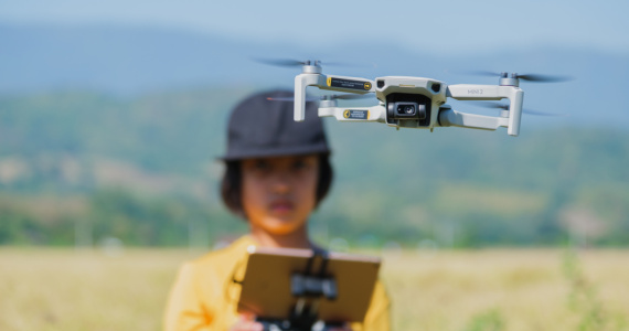Boy flies drone in field