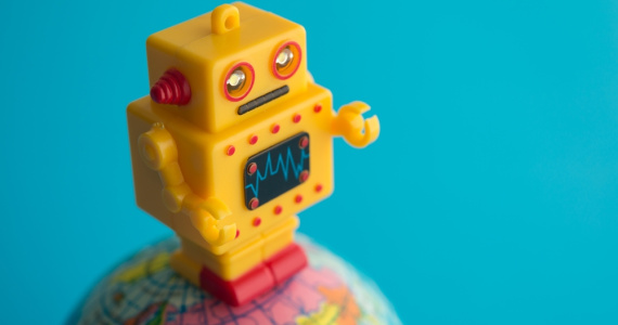 Cute yellow robot stands on a globe of the earth with blue background. 