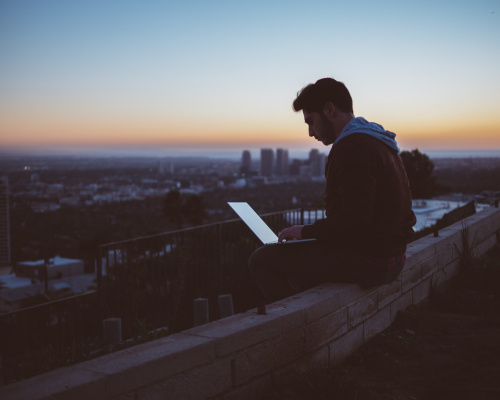Man sitting on Roof looking at computer screen