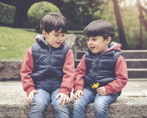 Two young boys sitting in a park