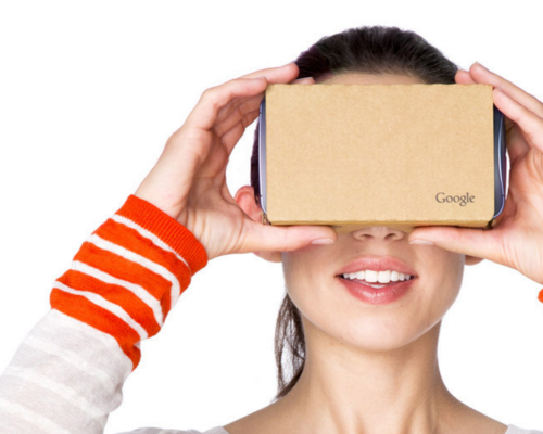 woman holding up google cardboard to her face