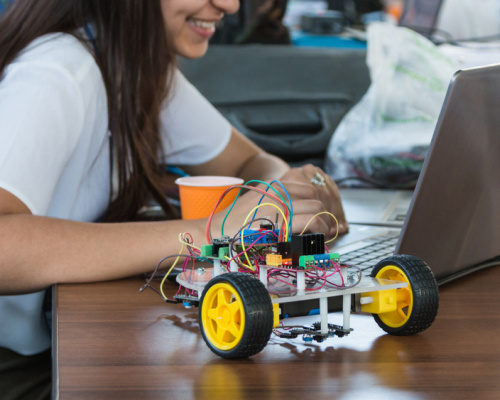 School girl coding to operate a robot in class