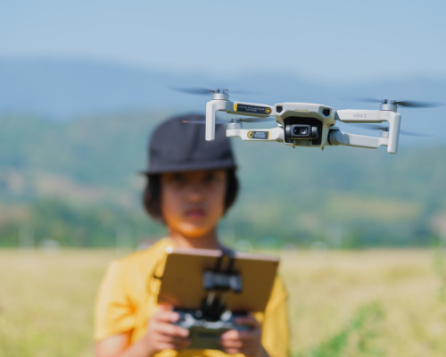 Boy flies drone in field