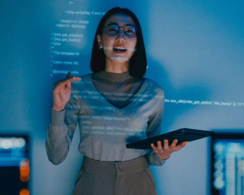 Female software developer manager presenting a strategy plan through a projected slideshow.