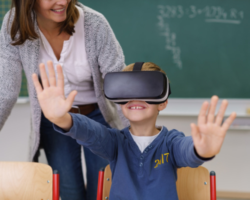Boy using virtual reality goggles in the classroom