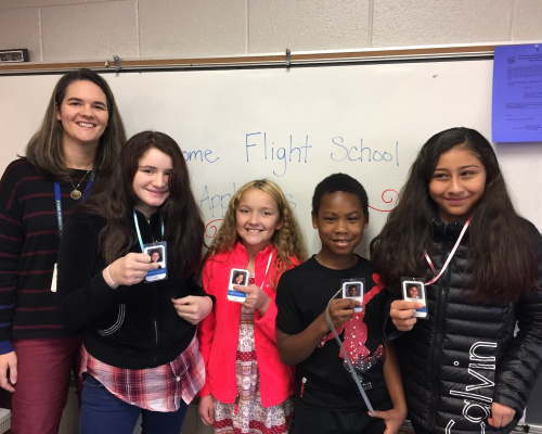 Angie Foreman and a group of students present their drone trainee badges after being accepted into the Flight School.